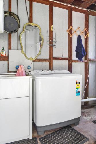 a washing machine in a room with a mirror at Sorrento on Jeffery in Agnes Water