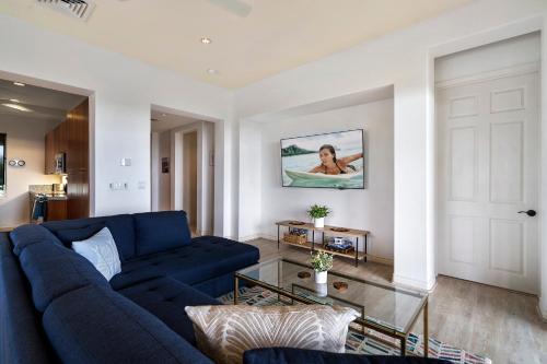 a living room with a blue couch and a glass table at J3 Kumulani in Hapuna Beach