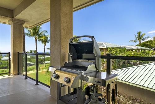 a grill on a balcony with a view of a house at J3 Kumulani in Hapuna Beach