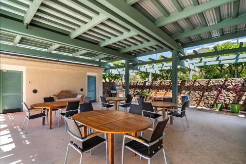 an outdoor patio with wooden tables and chairs at J3 Kumulani in Hapuna Beach