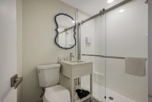 a bathroom with a toilet and a sink and a mirror at Hotel Cabana Oceanfront/Boardwalk in Wildwood