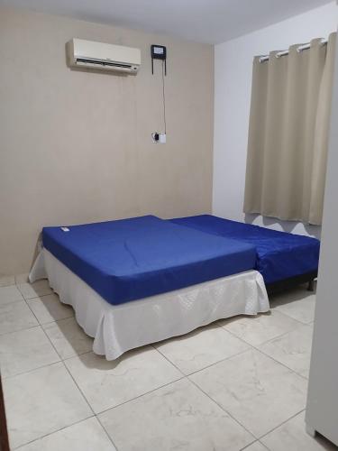 a bedroom with a blue bed in a room at Casa Jacuipe temporada in Camaçari