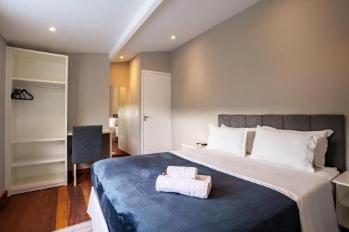 a bedroom with a large bed with a blue blanket at POUSADA HAPPY DAY PARATY in Paraty
