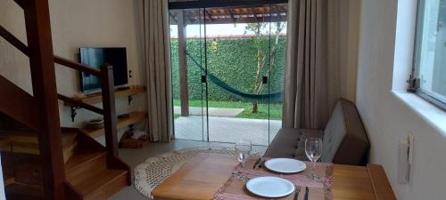 a dining room table with a glass door to a garden at Casa da Pitanga Lumiar in Lumiar