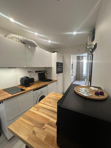 une cuisine avec un comptoir noir dans une pièce dans l'établissement Moderne et lumineux, à Asnières-sur-Seine