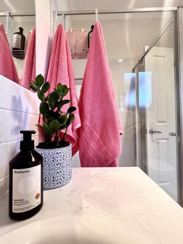 a bathroom with pink towels and a plant on a counter at Vita Lenta - 3 Bed, 2 Bath in Tanunda