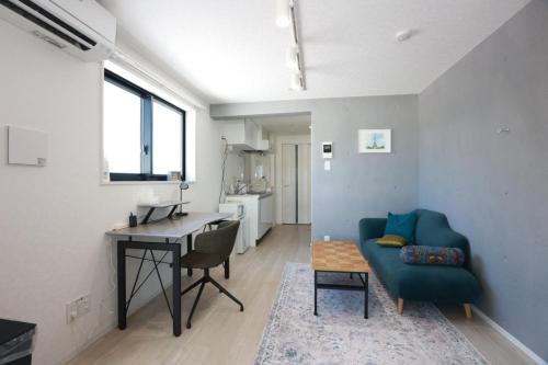 a living room with a green couch and a desk at Comfort Boutique Room in Tokyo
