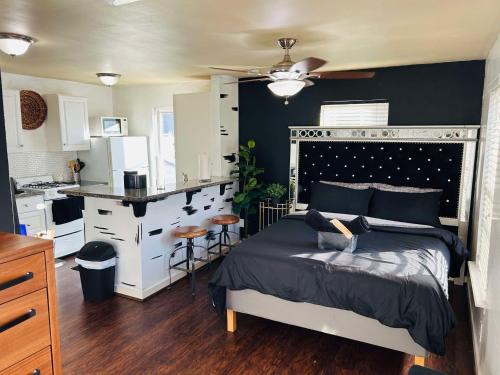 a bedroom with a large bed and a kitchen at Trendy and modern apartment at rice village in Houston