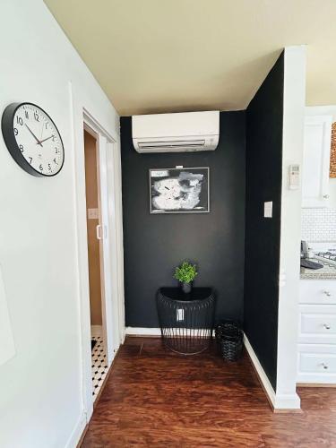 a hallway with a clock on the wall and a chair at Trendy and modern apartment at rice village in Houston