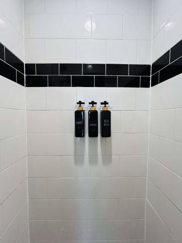 three bottles on a wall in a bathroom at Trendy and modern apartment at rice village in Houston