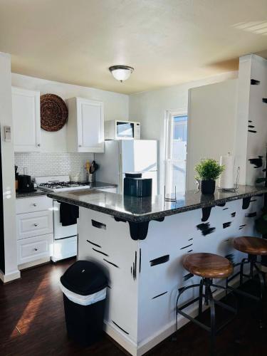 a kitchen with white cabinets and a black counter top at Trendy and modern apartment at rice village in Houston