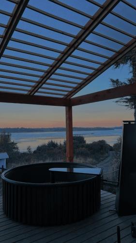 a hot tub on a deck with a pergola at Refugio con Vista al Mar y Paz in Vilupulli
