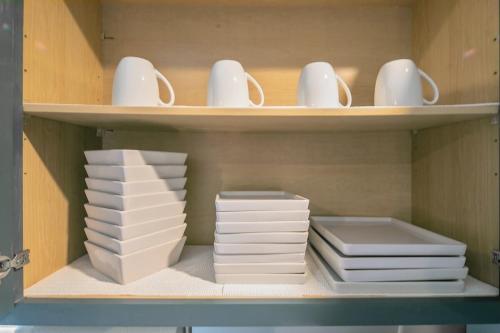 a shelf with stacks of plates and cups and dishes at Ellis Hideaway in Fayetteville