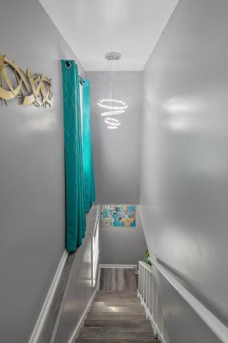 a hallway with a staircase with green curtains at Ellis Hideaway in Fayetteville