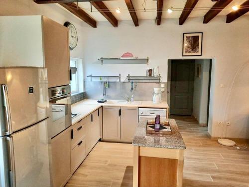 Il comprend une grande cuisine équipée d'un réfrigérateur et d'un comptoir. dans l'établissement Gîte confortable près de Saumur : 2 chambres, jardin clos, terrasse, proche sites touristiques - FR-1-622-4, à Brain-sur-Allonnes