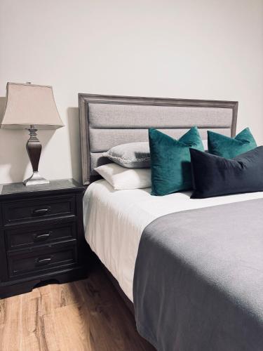 a bedroom with a bed with blue pillows and a lamp at Deluxe Queen Room Private Ensuite Vancouver West in Vancouver