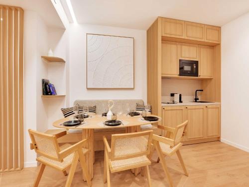 une salle à manger avec une table et des chaises en bois dans l'établissement Authentic apartment - 3BR 6P - Moulin Rouge, à Paris