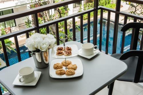 a table with two plates of donuts on a balcony at The Title KR Beach Condotel Rawai Beach in Rawai Beach