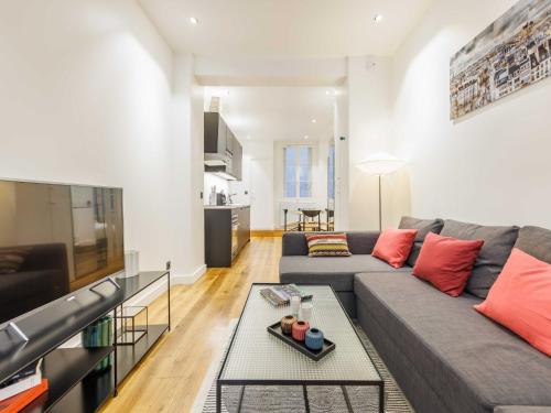 un salon avec un canapé et une télévision dans l'établissement Cosy apartment - 1BR 4P - Near Champs-Élysées, à Paris