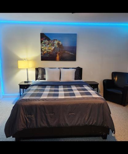 a bedroom with a bed and a black chair at Platinum Staycation EnSuite - Free Onsite Parking , Washroom Ensuite , Shared Full kitchen in London