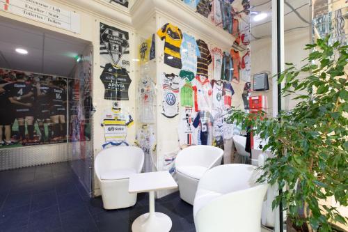 a salon with white chairs and posters on the wall at Logis Hôtel du Haut-Bugey in Oyonnax