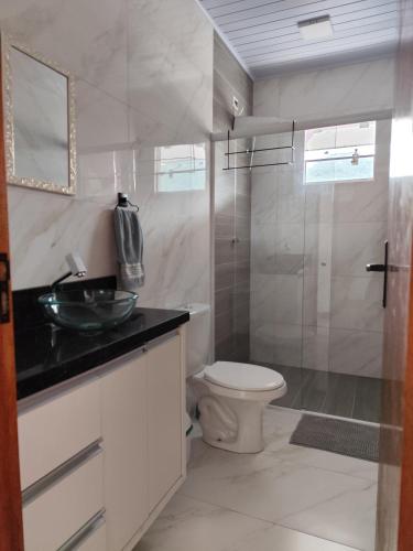 a bathroom with a toilet and a sink and a shower at Apartamento kit aconchegante 1 in Matinhos