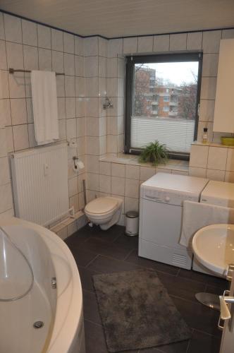 a bathroom with a toilet and a sink and a tub at Cityapartment An der Petrikirche in Braunschweig