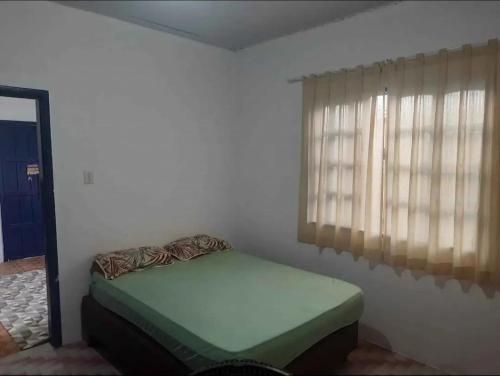a bedroom with a bed in a room with a window at Casa Praia Grande in Arraial do Cabo