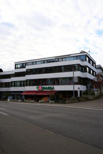 a large white building on the side of a street at Duplex Apartment Bülach Station in Bülach