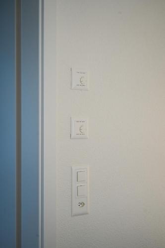 a white door with four light switches on it at Duplex Apartment Bülach Station in Bülach