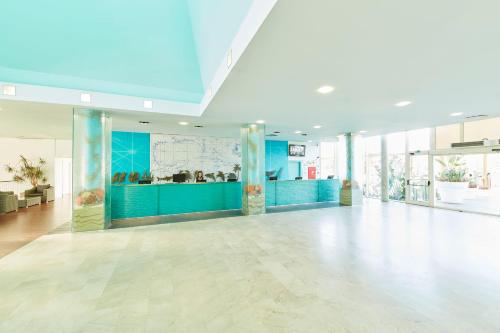 a large room with a lobby with blue walls at PortAventura Hotel Caribe - Includes unlimited access to PortAventura Park & 1 access to Ferrari Land in Salou
