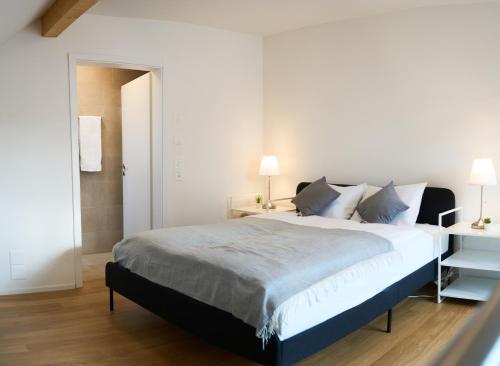 a bedroom with a large bed and two lamps at Duplex Apartment Bülach Station in Bülach