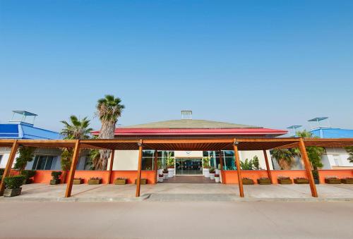 a large building with a large entrance with palm trees at PortAventura Hotel Caribe - Includes unlimited access to PortAventura Park & 1 access to Ferrari Land in Salou
