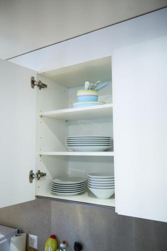 a kitchen cupboard with plates and dishes in it at Duplex Apartment Bülach Station in Bülach