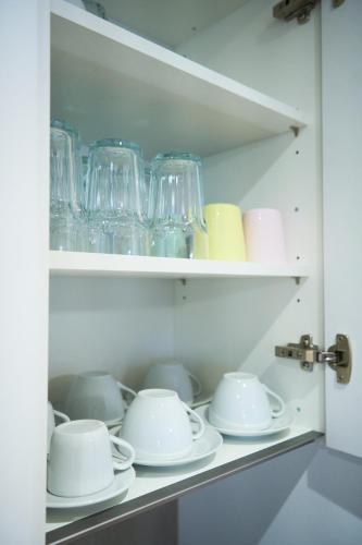 a cupboard filled with glasses and saucers at Duplex Apartment Bülach Station in Bülach