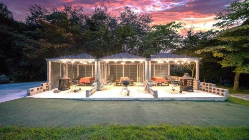 a pavilion with chairs and tables on a lawn at Yangyang Hajodae Ecoheim Four Seasons Heated Pool N Spa Pension in Yangyang