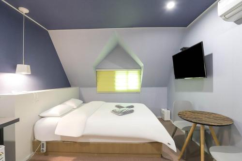 a bedroom with a white bed and a small table at Hotel Stay Q Daejeon in Daejeon
