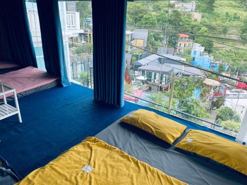 a room with two beds and a large window at Nhà Trên Mây - Homstay Tam Đảo in Tam Ðảo