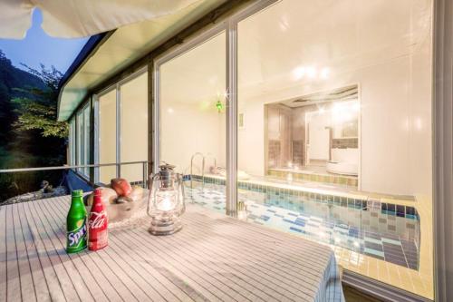 a table on a balcony with a view of a pool at Gapyeong aqua velly poolvilla jeongaeksil poolvilla and spa in Gapyeong