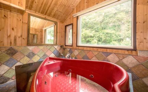 a red sink in a bathroom with a window at Gapyeong aqua velly poolvilla jeongaeksil poolvilla and spa in Gapyeong