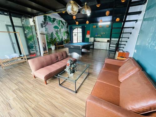 a living room with couches and a ping pong table at Nhà Trên Mây - Homstay Tam Đảo in Tam Ðảo