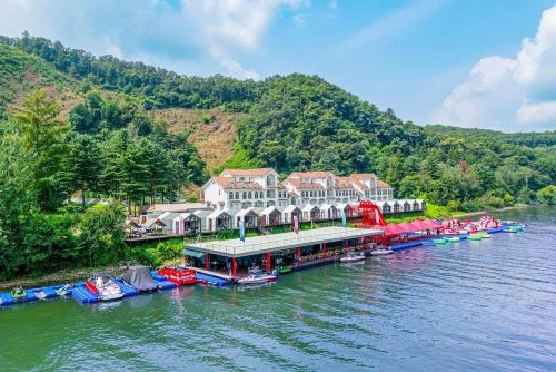une station balnéaire sur une rivière avec des bateaux dans l'eau dans l'établissement Hongcheon Monterio Resort, à Hongcheon