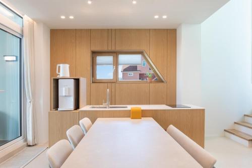 a kitchen with a white table and a refrigerator at Gangneung Atopool Villa in Gangneung