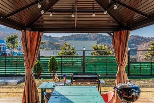 an outdoor patio with a table and a grill at Yeoncheon Pension Nolmung dogs allowed in Yeoncheon