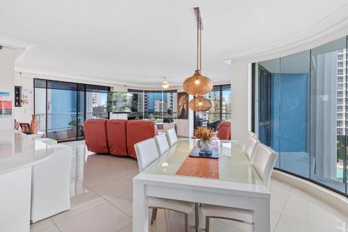 a dining room with a white table and chairs at Aegean Apartments Surfers Paradise in Gold Coast