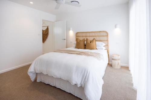 a white bedroom with a large white bed with pillows at Olas Villa 1 - Plunge Pool & Walk to Beach in Anna Bay