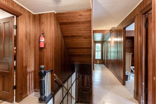 a hallway with wood paneling and a fire extinguisher on the wall at Pavillion Paradise is Walking Distance to Lake Michigan in Holland