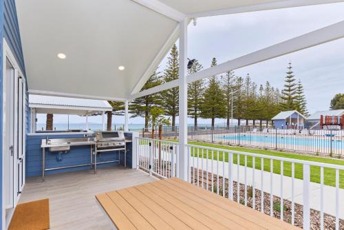 a balcony with a desk and a view of the water at RAC Esperance Holiday Park in Esperance