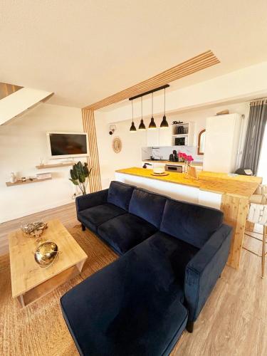a living room with a blue couch and a kitchen at Sunset View in Friar's Bay