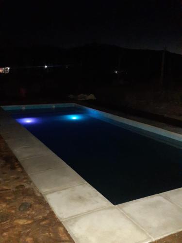 a swimming pool at night with blue lights at Cabañas Angualasto in Uspallata